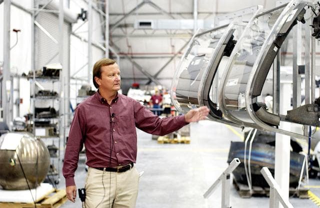 NASA image: KENNEDY SPACE CENTER, FLA. - While talking to the media in the RLV Hangar, Shuttle Launch Director Mike Leinbach points to the model of the leading edge of an orbiter’s left wing that is being used to reconstruct Columbia’s wing with the recovered debris.  The items shipped to KSC number more than 82,000 and weigh 84,800 pounds or 38 percent of the total dry weight of Columbia.  Of those items, 78,760 have been identified, with 753 placed on the left wing grid in the Hangar.
