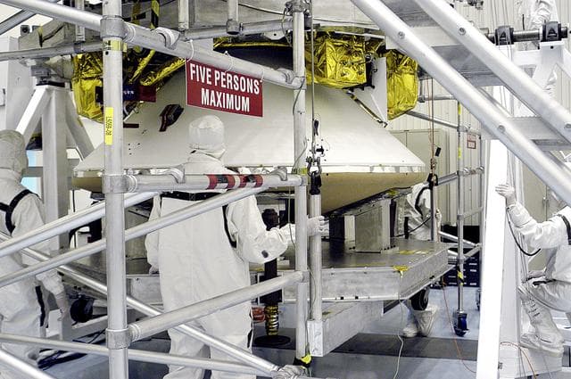 NASA image: KENNEDY SPACE CENTER, FLA. - Workers in the  Payload Hazardous Servicing Facility stand by while the cruise stage is mated to the Mars Exploration Rover 2 (MER-2) entry vehicle.    The cruise stage includes fuel tanks, thruster clusters and avionics for steering and propulsion.  NASA's twin Mars Exploration Rovers are designed to study the history of water on Mars. These robotic geologists are equipped with a robotic arm, a drilling tool, three spectrometers, and four pairs of cameras that allow them to have a human-like, 3D view of the terrain. Each rover could travel as far as 100 meters in one day to act as Mars scientists' eyes and hands, exploring an environment where humans can't yet go.  MER-2 is scheduled to launch June 5 as MER-A aboard a Delta rocket from Cape Canaveral Air Force Station.