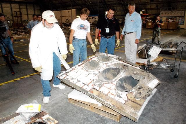 NASA image: KENNEDY SPACE CENTER, FLA. -  Members of the Columbia Reconstruction Project Team work with pieces of debris in the RLV Hangar. The items shipped to KSC number more than 82,000 and weigh 84,800 pounds or 38 percent of the total dry weight of Columbia. Of those items, 78,760 have been identified, with 753 placed on the left wing grid in the Hangar.