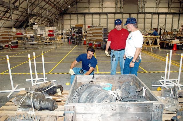 NASA image: KENNEDY SPACE CENTER, FLA. -  Members of the Columbia Reconstruction Project Team work with pieces of debris in the RLV Hangar. The items shipped to KSC number more than 82,000 and weigh 84,800 pounds or 38 percent of the total dry weight of Columbia. Of those items, 78,760 have been identified, with 753 placed on the left wing grid in the Hangar.