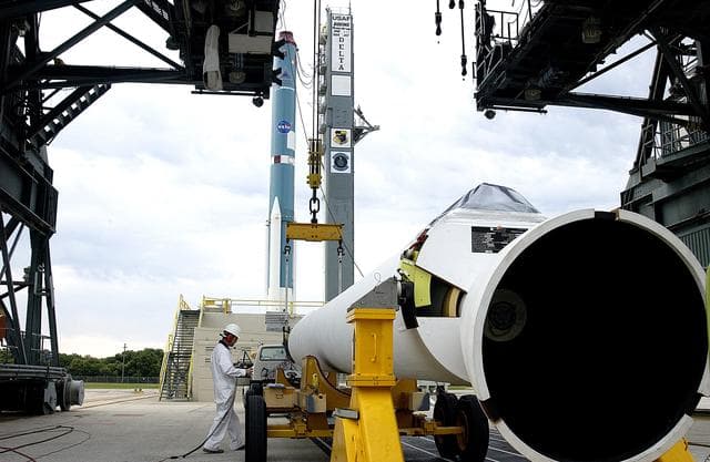 NASA image: KENNEDY SPACE CENTER, FLA. -  On Launch Complex 17-A, Cape Canaveral Air Force Station, a solid rocket booster is prepared to raise it to vertical and lift up the launch tower.  It is one of nine that will be mated to the Delta rocket (in the background) to launch Mars Exploration Rover 2. NASA’s twin Mars Exploration Rovers are designed to study the history of water on Mars. These robotic geologists are equipped with a robotic arm, a drilling tool, three spectrometers, and four pairs of cameras that allow them to have a human-like, 3D view of the terrain. Each rover could travel as far as 100 meters in one day to act as Mars scientists' eyes and hands, exploring an environment where humans can’t yet go.  MER-2 is scheduled to launch June 5 as MER-A.  MER-1 (MER-B) will launch June 25.