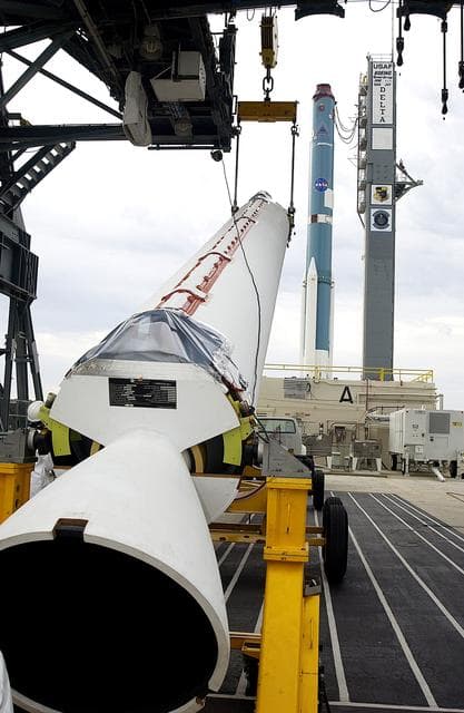 NASA image: KENNEDY SPACE CENTER, FLA. - On Launch Complex 17-A, Cape Canaveral Air Force Station, a solid rocket booster is raised off the transporter.  When vertical, it will be lifted up the launch tower and mated to the Delta rocket (in the background) to launch Mars Exploration Rover 2. NASA’s twin Mars Exploration Rovers are designed to study the history of water on Mars. These robotic geologists are equipped with a robotic arm, a drilling tool, three spectrometers, and four pairs of cameras that allow them to have a human-like, 3D view of the terrain. Each rover could travel as far as 100 meters in one day to act as Mars scientists' eyes and hands, exploring an environment where humans can’t yet go.  MER-2 is scheduled to launch June 5 as MER-A.  MER-1 (MER-B) will launch June 25.