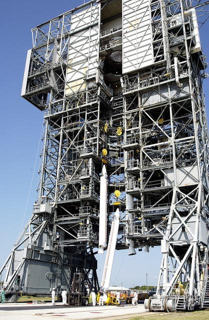 NASA image: KENNEDY SPACE CENTER, FLA. - A third solid rocket booster (SRB) is lifted up the launch tower  on Launch Complex 17-A, Cape Canaveral Air Force Station.  They are three of nine SRBs that will be mated to the Delta rocket to launch Mars Exploration Rover 2. NASA’s twin Mars Exploration Rovers are designed to study the history of water on Mars. These robotic geologists are equipped with a robotic arm, a drilling tool, three spectrometers, and four pairs of cameras that allow them to have a human-like, 3D view of the terrain. Each rover could travel as far as 100 meters in one day to act as Mars scientists' eyes and hands, exploring an environment where humans can’t yet go.  MER-2 is scheduled to launch June 5 as MER-A.  MER-1 (MER-B) will launch June 25.