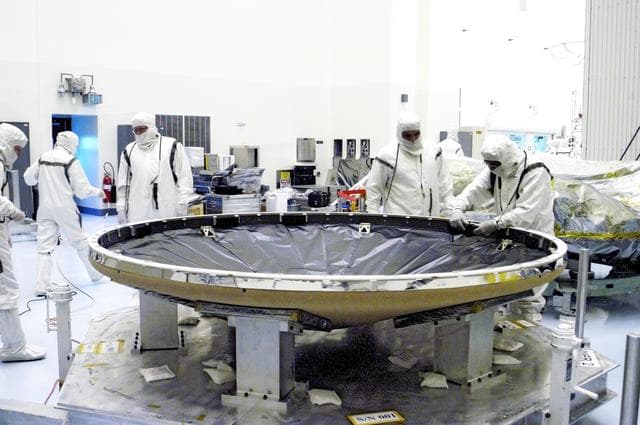 NASA image: KENNEDY SPACE CENTER, FLA. - Workers in the Payload Hazardous Servicing Facility prepare the heat shield that will be attached to the backshell, surrounding Mars Exploration Rover 1 (MER-1).  NASA's twin Mars Exploration Rovers are designed to study the history of water on Mars. These robotic geologists are equipped with a robotic arm, a drilling tool, three spectrometers, and four pairs of cameras that allow them to have a human-like, 3D view of the terrain. Each rover could travel as far as 100 meters in one day to act as Mars scientists' eyes and hands, exploring an environment where humans can't yet go.  MER-1 is scheduled to launch June 25 as MER-B aboard a Delta II rocket from Cape Canaveral Air Force Station.