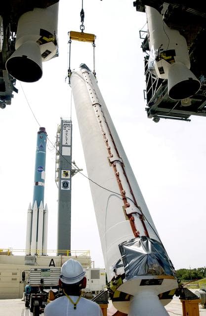 NASA image: KENNEDY SPACE CENTER, FLA. -  A solid rocket booster (SRB) is lifted to vertical on Launch Complex 17-A, Cape Canaveral Air Force Station, joining two others in the launch tower.  They are three of nine SRBs that will help launch Mars Exploration Rover 2.  NASA’s twin Mars Exploration Rovers are designed to study the history of water on Mars. These robotic geologists are equipped with a robotic arm, a drilling tool, three spectrometers, and four pairs of cameras that allow them to have a human-like, 3D view of the terrain. Each rover could travel as far as 100 meters in one day to act as Mars scientists' eyes and hands, exploring an environment where humans can’t yet go.  MER-2 is scheduled to launch June 5 as MER-A.  MER-1 (MER-B) will launch June 25.
