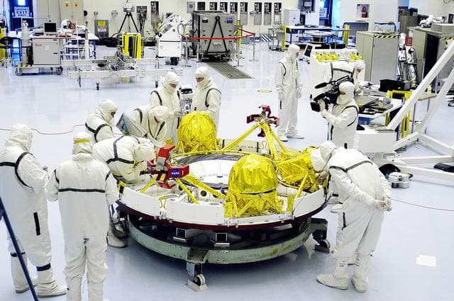 NASA image: KENNEDY SPACE CENTER, FLA. - Technicians in the Payload Hazardous Servicing Facility prepare the cruise stage for Mars Exploration Rover 1 (MER-1) for integration with the aeroshell, the entry vehicle.   NASA’s twin Mars Exploration Rovers are designed to study the history of water on Mars. These robotic geologists are equipped with a robotic arm, a drilling tool, three spectrometers, and four pairs of cameras that allow them to have a human-like, 3D view of the terrain. Each rover could travel as far as 100 meters in one day to act as Mars scientists' eyes and hands, exploring an environment where humans can’t yet go.  The MER-1 is scheduled to launch June 25 from Launch Pad 17-A, Cape Canaveral Air Force Station.