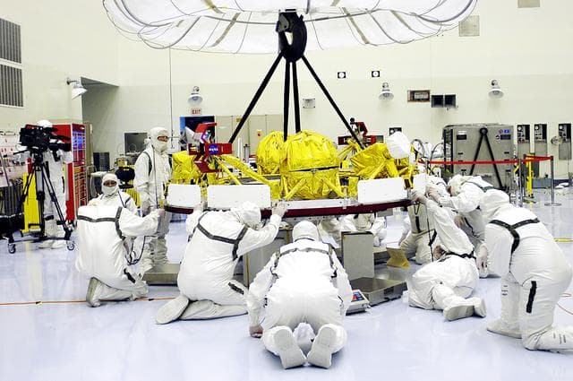 NASA image: KENNEDY SPACE CENTER, FLA. - In the Payload Hazardous Servicing Facility, workers help guide the cruise stage of Mars Exploration Rover 1 (MER-1) as it is lowered onto blocks.  The cruise stage will be integrated with the aeroshell, the entry vehicle.   NASA’s twin Mars Exploration Rovers are designed to study the history of water on Mars. These robotic geologists are equipped with a robotic arm, a drilling tool, three spectrometers, and four pairs of cameras that allow them to have a human-like, 3D view of the terrain. Each rover could travel as far as 100 meters in one day to act as Mars scientists' eyes and hands, exploring an environment where humans can’t yet go.  The MER-1 is scheduled to launch June 25 from Launch Pad 17-A, Cape Canaveral Air Force Station.