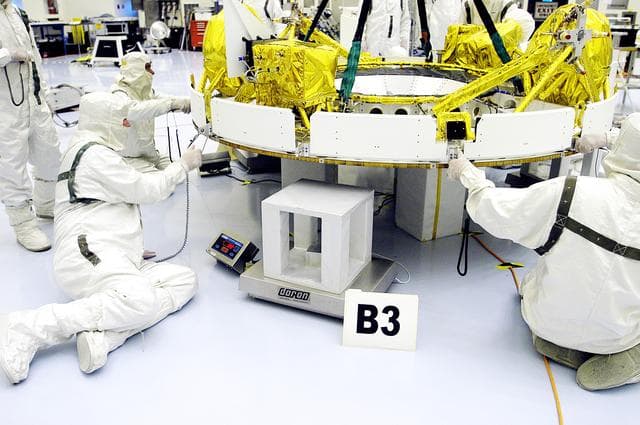 NASA image: KENNEDY SPACE CENTER, FLA. - In the Payload Hazardous Servicing Facility, workers help guide the cruise stage of Mars Exploration Rover 1 (MER-1) as it is lowered onto blocks.  The cruise stage will be integrated with the aeroshell, the entry vehicle.   NASA’s twin Mars Exploration Rovers are designed to study the history of water on Mars. These robotic geologists are equipped with a robotic arm, a drilling tool, three spectrometers, and four pairs of cameras that allow them to have a human-like, 3D view of the terrain. Each rover could travel as far as 100 meters in one day to act as Mars scientists' eyes and hands, exploring an environment where humans can’t yet go.  The MER-1 is scheduled to launch June 25 from Launch Pad 17-A, Cape Canaveral Air Force Station.