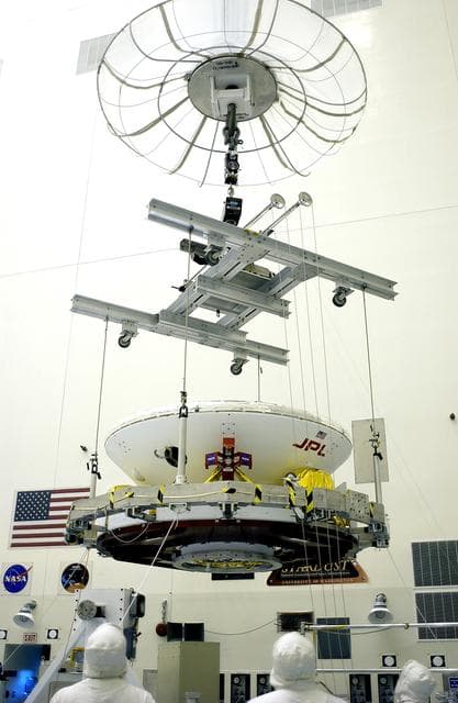 NASA image: KENNEDY SPACE CENTER, FLA. - In the Payload Hazardous Servicing Facility, an overhead crane lifts the Mars Exploration Rover 2 (MER-2) to move it to a spin table.  NASA’s twin Mars Exploration Rovers are designed to study the history of water on Mars. These robotic geologists are equipped with a robotic arm, a drilling tool, three spectrometers, and four pairs of cameras that allow them to have a human-like, 3D view of the terrain. Each rover could travel as far as 100 meters in one day to act as Mars scientists' eyes and hands, exploring an environment where humans can’t yet go.  The MER-2 is scheduled to launch June 5 from Launch Pad 17-A, Cape Canaveral Air Force Station.