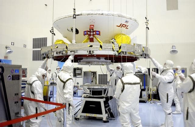 NASA image: KENNEDY SPACE CENTER, FLA. - In the Payload Hazardous Servicing Facility, the Mars Exploration Rover 2 (MER-2) is lowered toward the spin table.  NASA’s twin Mars Exploration Rovers are designed to study the history of water on Mars. These robotic geologists are equipped with a robotic arm, a drilling tool, three spectrometers, and four pairs of cameras that allow them to have a human-like, 3D view of the terrain. Each rover could travel as far as 100 meters in one day to act as Mars scientists' eyes and hands, exploring an environment where humans can’t yet go.  The MER-2 is scheduled to launch June 5 from Launch Pad 17-A, Cape Canaveral Air Force Station.