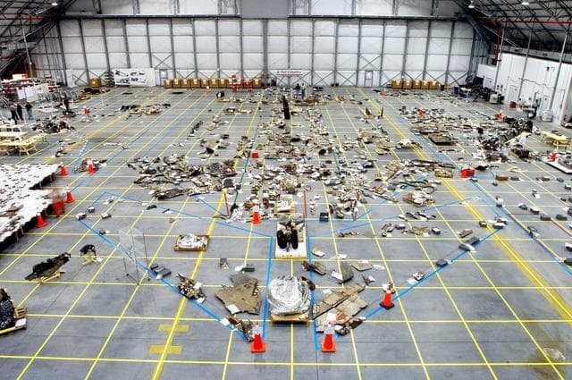 NASA image: KENNEDY SPACE CENTER, FLA. - An overview of the Columbia debris hangar shows the orbiter outline on the floor with some of the 78,760 pieces identified to date.  More than 82,500 pieces of shuttle debris have been rcovered.