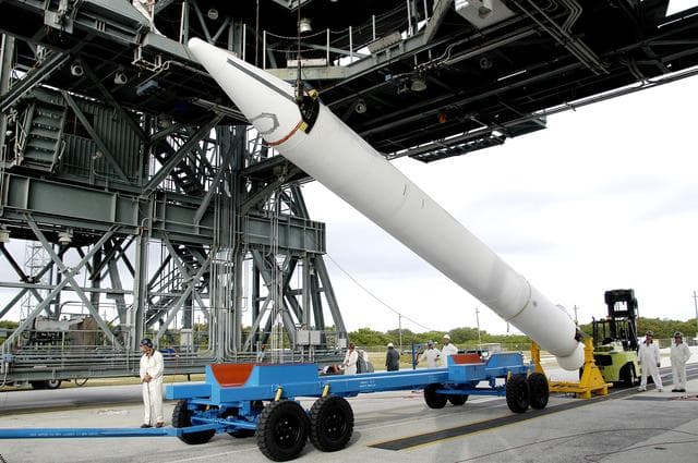NASA image: KENNEDY SPACE CENTER, FLA. - On Launch Complex 17-B, Cape Canaveral Air Force Station, a solid rocket booster is raised off  its transporter to lift it to vertical.  It will be mated to the Delta II rocket for the Mars Exploration Rover 1 (MER-1) launch June 25.  NASA’s twin Mars Exploration Rovers are designed to study the history of water on Mars. These robotic geologists are equipped with a robotic arm, a drilling tool, three spectrometers, and four pairs of cameras that allow them to have a human-like, 3D view of the terrain. Each rover could travel as far as 100 meters in one day to act as Mars scientists' eyes and hands, exploring an environment where humans can’t yet go.  MER-2 (MER-A) will launch June 5.