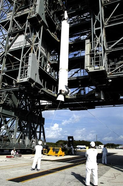 NASA image: KENNEDY SPACE CENTER, FLA. - On Launch Complex 17-B, Cape Canaveral Air Force Station, a solid rocket booster if lifted up the launch tower.  It will be mated to the Delta II rocket for the Mars Exploration Rover 1 (MER-1) launch June 25.  NASA’s twin Mars Exploration Rovers are designed to study the history of water on Mars. These robotic geologists are equipped with a robotic arm, a drilling tool, three spectrometers, and four pairs of cameras that allow them to have a human-like, 3D view of the terrain. Each rover could travel as far as 100 meters in one day to act as Mars scientists' eyes and hands, exploring an environment where humans can’t yet go.  MER-2 (MER-A) will launch June 5.