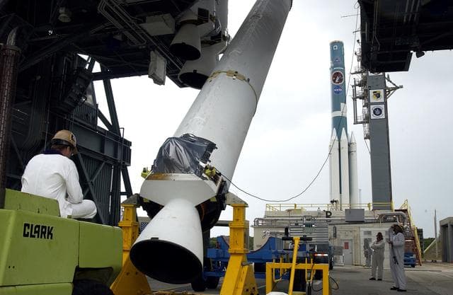 NASA image: KENNEDY SPACE CENTER, FLA. -  On Launch Complex 17-B, Cape Canaveral Air Force Station, a solid rocket booster is lifted to vertical.  It will be mated to the Delta II rocket (in the background) for the Mars Exploration Rover 1 (MER-1) launch June 25.  NASA’s twin Mars Exploration Rovers are designed to study the history of water on Mars. These robotic geologists are equipped with a robotic arm, a drilling tool, three spectrometers, and four pairs of cameras that allow them to have a human-like, 3D view of the terrain. Each rover could travel as far as 100 meters in one day to act as Mars scientists' eyes and hands, exploring an environment where humans can’t yet go.  MER-2 (MER-A) will launch June 5.