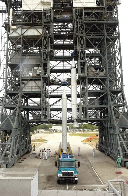 NASA image: KENNEDY SPACE CENTER, FLA. -  Another solid rocket booster is lifted up the launch tower on Launch Complex 17-B, Cape Canaveral Air Force Station.  It will be mated to the Delta II rocket for the Mars Exploration Rover 1 (MER-1) launch June 25.  NASA’s twin Mars Exploration Rovers are designed to study the history of water on Mars. These robotic geologists are equipped with a robotic arm, a drilling tool, three spectrometers, and four pairs of cameras that allow them to have a human-like, 3D view of the terrain. Each rover could travel as far as 100 meters in one day to act as Mars scientists' eyes and hands, exploring an environment where humans can’t yet go.  MER-2 (MER-A) will launch June 5.
