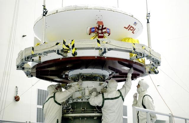 NASA image: KENNEDY SPACE CENTER, FLA. -  In the Payload Hazardous Servicing Facility, workers mate the Mars Exploration Rover-2 (MER-2) to the third stage of a Delta II rocket for launch on June 5.  NASA’s twin Mars Exploration Rovers are designed to study the history of water on Mars. These robotic geologists are equipped with a robotic arm, a drilling tool, three spectrometers, and four pairs of cameras that allow them to have a human-like, 3D view of the terrain. Each rover could travel as far as 100 meters in one day to act as Mars scientists' eyes and hands, exploring an environment where humans can’t yet go.  MER-1 (MER-B) will launch June 25.