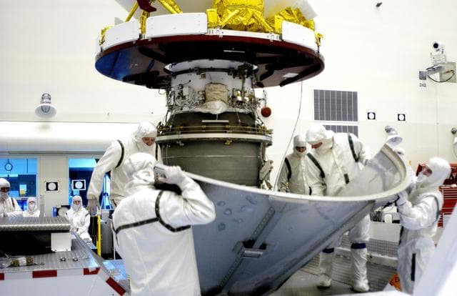 NASA image: KENNEDY SPACE CENTER, FLA. -  Workers in the Payload Hazardous Servicing Facility place the lower sections of the transport canister around the Mars Exploration Rover 2 (MER-2).  After encapsulation, it will be transferred to Launch Complex 17-A, Cape Canaveral Air Force Station.  MER-2 is one of NASA's twin Mars Exploration Rovers designed to study the history of water on Mars. These robotic geologists are equipped with a robotic arm, a drilling tool, three spectrometers, and four pairs of cameras that allow them to have a human-like, 3D view of the terrain. Each rover could travel as far as 100 meters in one day to act as Mars scientists' eyes and hands, exploring an environment where humans can't yet go.  MER-2 is scheduled to launch no earlier than June 8 as MER-A aboard a Delta II rocket.
