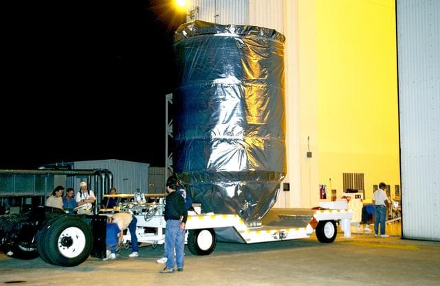 NASA image: KENNEDY SPACE CENTER, FLA. - The Mars Exploration Rover 2 (MER-2), inside the transport canister, is ready for transfer to Launch Pad 17-A, Cape Canaveral Air Force Station.  At the pad it will be mated to the Delta II rocket for launch.  MER-2 is one of NASA's twin Mars Exploration Rovers designed to study the history of water on Mars. These robotic geologists are equipped with a robotic arm, a drilling tool, three spectrometers, and four pairs of cameras that allow them to have a human-like, 3D view of the terrain. Each rover could travel as far as 100 meters in one day to act as Mars scientists' eyes and hands, exploring an environment where humans can't yet go.  MER-2 is scheduled to launch no earlier than June 8 as MER-A.