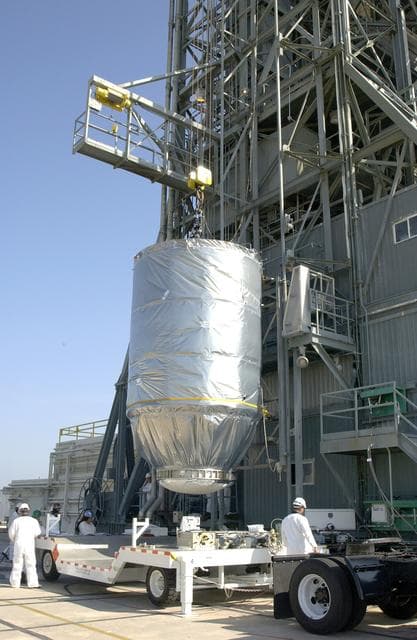 NASA image: KENNEDY SPACE CENTER, FLA. - On Launch Pad 17-A, Cape Canaveral Air Force Station, the Mars Exploration Rover 2 (MER-2), inside the transport canister, is lifted off the transporter and into the launch tower where it will be mated to the Delta II rocket for launch.  MER-2 is one of NASA's twin Mars Exploration Rovers designed to study the history of water on Mars. These robotic geologists are equipped with a robotic arm, a drilling tool, three spectrometers, and four pairs of cameras that allow them to have a human-like, 3D view of the terrain. Each rover could travel as far as 100 meters in one day to act as Mars scientists' eyes and hands, exploring an environment where humans can't yet go.  MER-2 is scheduled to launch no earlier than June 8 as MER-A.