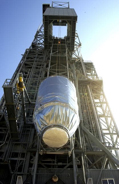 NASA image: KENNEDY SPACE CENTER, FLA. - On Launch Pad 17-A, Cape Canaveral Air Force Station, the Mars Exploration Rover 2 (MER-2), inside the transport canister, is lifted up the launch tower where it will be mated to the Delta II rocket for launch.  MER-2 is one of NASA's twin Mars Exploration Rovers designed to study the history of water on Mars. These robotic geologists are equipped with a robotic arm, a drilling tool, three spectrometers, and four pairs of cameras that allow them to have a human-like, 3D view of the terrain. Each rover could travel as far as 100 meters in one day to act as Mars scientists' eyes and hands, exploring an environment where humans can't yet go.  MER-2 is scheduled to launch no earlier than June 8 as MER-A.