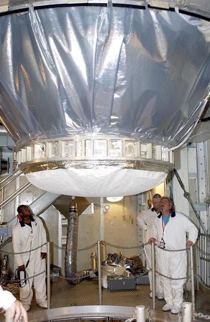 NASA image: KENNEDY SPACE CENTER, FLA. -  On Launch Pad 17-A, Cape Canaveral Air Force Station,  workers watch as the Mars Exploration Rover 2 (MER-2), inside the transport canister, is lowered toward the Delta II rocket for mating.  MER-2 is one of NASA's twin Mars Exploration Rovers designed to study the history of water on Mars. These robotic geologists are equipped with a robotic arm, a drilling tool, three spectrometers, and four pairs of cameras that allow them to have a human-like, 3D view of the terrain. Each rover could travel as far as 100 meters in one day to act as Mars scientists' eyes and hands, exploring an environment where humans can't yet go.  MER-2 is scheduled to launch no earlier than June 8 as MER-A.
