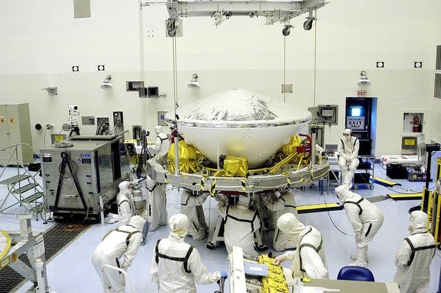 NASA image: KENNEDY SPACE CENTER, FLA. - In the Payload Hazardous Servicing Facility, workers prepare to lift the Mars Exploration Rover-1 (MER-B) onto a spin table during preflight processing of the spacecraft.  The rover is scheduled to launch aboard a Delta II rocket on June 25.  NASA’s twin Mars Exploration Rovers are designed to study the history of water on Mars. These robotic geologists are equipped with a robotic arm, a drilling tool, three spectrometers, and four pairs of cameras that allow them to have a human-like, 3D view of the terrain. Each rover could travel as far as 100 meters in one day to act as Mars scientists' eyes and hands, exploring an environment where humans are not yet able to go. The launch of MER-2 (MER-A) is tentatively set for June 8.