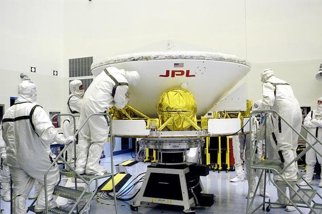 NASA image: KENNEDY SPACE CENTER, FLA. - In the Payload Hazardous Servicing Facility, workers secure the Mars Exploration Rover-1 (MER-B) to a spin table during preflight processing of the spacecraft.  The rover is scheduled to launch aboard a Delta II rocket on June 25.  NASA’s twin Mars Exploration Rovers are designed to study the history of water on Mars. These robotic geologists are equipped with a robotic arm, a drilling tool, three spectrometers, and four pairs of cameras that allow them to have a human-like, 3D view of the terrain. Each rover could travel as far as 100 meters in one day to act as Mars scientists' eyes and hands, exploring an environment where humans are not yet able to go. The launch of MER-2 (MER-A) is tentatively set for June 8.