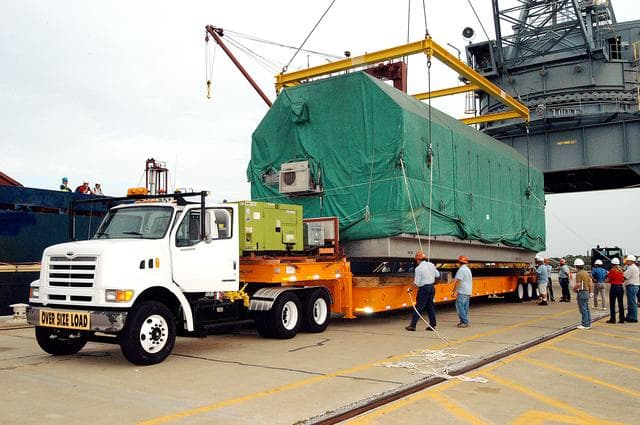 NASA image: KENNEDY SPACE CENTER, FLA. - At Port Canaveral, workers release the overhead crane that lifted the Pressurized Module of the Japanese Experiment Module (JEM) from the ship onto the truck bed.  The container transport ship carrying JEM departed May 2 from Yokohama Harbor in Japan for the voyage to the United States. The National Space Development Agency of Japan (NASDA) developed the laboratory at the Tsukuba Space Center near Tokyo. The Pressurized Module is the first element of the JEM, named "Kibo" (Hope), to be delivered to KSC, and will be transferred to KSC’s Space Station Processing Facility.  The JEM is Japan's primary contribution to the Station. It will enhance the unique research capabilities of the orbiting complex by providing an additional environment for astronauts to conduct science experiments.  The JEM also includes an exposed facility (platform) for space environment experiments, a robotic manipulator system, and two logistics modules. The various JEM components will be  assembled in space over the course of three Shuttle missions.
