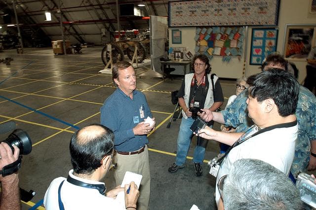 NASA image: KENNEDY SPACE CENTER, FLA. - In the Columbia Debris Hangar,  Shuttle Launch Director Mike Leinbach  (right) talks to the media about activities that have taken place since the Columbia accident on Feb. 1, 2003.  STS-107 debris recovery and reconstruction operations are winding down.  To date, nearly 84,000 pieces of debris have been recovered and sent to KSC. That represents about 38 percent of the dry weight of Columbia, equaling almost 85,000 pounds.