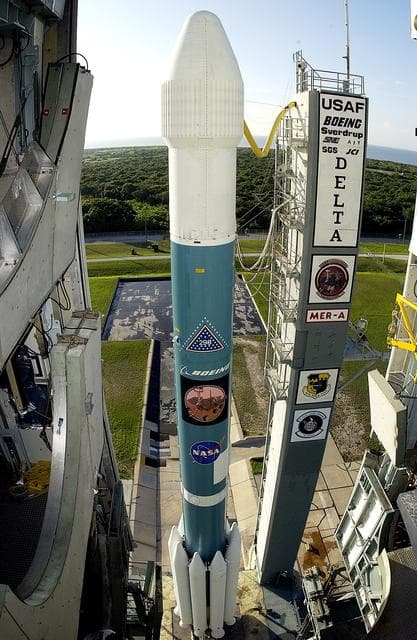 NASA image: KENNEDY SPACE CENTER, FLA. -    The launch tower on Launch Complex 17-A, Cape Canaveral Air Force Station, clears the Boeing Delta II rocket and its Mars Exploration Rover (MER-A) payload in preparation for a second attempt at launch.  The first attempt on June 8, 2003, was scrubbed due to bad weather in the vicinity.  MER-A is the first of two rovers being launched to Mars.  When the two rovers arrive at Mars in 2004, they will bounce to airbag-cushioned landings at sites offering a balance of favorable conditions for safe landings and interesting science. The rovers see sharper images, can explore farther and examine rocks better than anything that has ever landed on Mars.  The designated site for MER-A mission is Gusev Crater, which appears to have been a crater lake.  The second rover, MER-B, is scheduled to launch June 25.