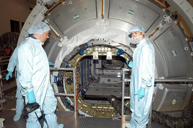 NASA image: KENNEDY SPACE CENTER, FLA. -  Workers in the Space Station Processing Facility stand by after opening the hatch on the Italian-built Node 2, a future element of the International Space Station.  Node 2 arrived at KSC June 1.  The second of three Station connecting modules, the module  attaches to the end of the U.S. Lab and provides attach locations for the Japanese laboratory, European laboratory, the Centrifuge Accommodation Module and, later, Multipurpose Logistics Modules. It will provide the primary docking location for the Shuttle when a pressurized mating adapter is attached to Node 2.  Installation of the module will complete  the U.S. Core of the ISS.  Node 2 is the designated payload for mission STS-120.  No orbiter or launch date has been determined yet.Installation of the module will complete  the U.S. Core of the ISS.  Node 2 is the designated payload for mission STS-120.  No orbiter or launch date has been determined yet.Installation of the module will complete  the U.S. Core of the ISS.  Node 2 is the designated payload for mission STS-120.  No orbiter or launch date has been determined yet.