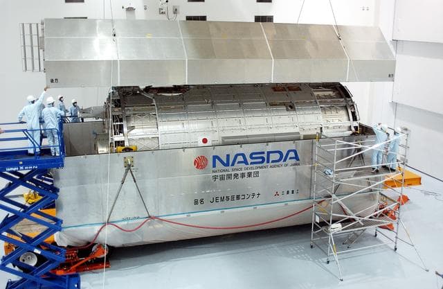 NASA image: KENNEDY SPACE CENTER, FLA. -   In the Space Station Processing Facility, the lid is removed from the container with the Japanese Experiment Module (JEM) pressure module inside.  A research laboratory, the pressurized module is the first element of the JEM, named "Kibo" (Hope), to be delivered to KSC.   The National Space Development Agency of Japan (NASDA) developed the laboratory at the Tsukuba Space Center near Tokyo and is Japan's primary contribution to the Station. It will enhance the unique research capabilities of the orbiting complex by providing an additional environment for astronauts to conduct science experiments.  The JEM also includes an exposed facility (platform) for space environment experiments, a robotic manipulator system, and two logistics modules. The various JEM components will be  assembled in space over the course of three Shuttle missions.