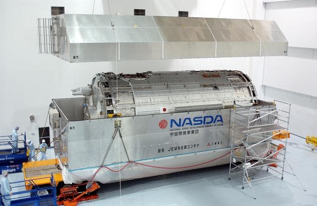 NASA image: KENNEDY SPACE CENTER, FLA. -  In the Space Station Processing Facility, the lid is removed from the container with the Japanese Experiment Module (JEM) pressure module inside.  A research laboratory, the pressurized module is the first element of the JEM, named "Kibo" (Hope), to be delivered to KSC.   The National Space Development Agency of Japan (NASDA) developed the laboratory at the Tsukuba Space Center near Tokyo and is Japan's primary contribution to the Station. It will enhance the unique research capabilities of the orbiting complex by providing an additional environment for astronauts to conduct science experiments.  The JEM also includes an exposed facility (platform) for space environment experiments, a robotic manipulator system, and two logistics modules. The various JEM components will be  assembled in space over the course of three Shuttle missions.