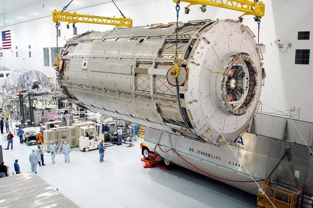 NASA image: KENNEDY SPACE CENTER, FLA. -   Removed from its shipping canister (lower right), the Japanese Experiment Module (JEM) pressure module is moved across the floor of the Space Station Processing Facility to a work stand.  A research laboratory, the pressurized module is the first element of the JEM, named "Kibo" (Hope), to be delivered to KSC.   The National Space Development Agency of Japan (NASDA) developed the laboratory at the Tsukuba Space Center near Tokyo and is Japan's primary contribution to the Station. It will enhance the unique research capabilities of the orbiting complex by providing an additional environment for astronauts to conduct science experiments.  The JEM also includes an exposed facility (platform) for space environment experiments, a robotic manipulator system, and two logistics modules. The various JEM components will be  assembled in space over the course of three Shuttle missions.