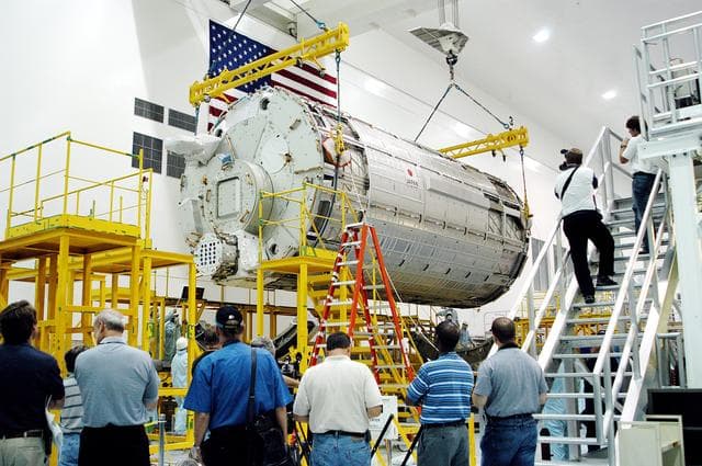 NASA image: KENNEDY SPACE CENTER, FLA. - In the Space Station Processing Facility, the Japanese Experiment Module (JEM) pressure module is moved toward a work stand.  A research laboratory, the pressurized module is the first element of the JEM, named "Kibo" (Hope), to be delivered to KSC.   The National Space Development Agency of Japan (NASDA) developed the laboratory at the Tsukuba Space Center near Tokyo and is Japan's primary contribution to the Station. It will enhance the unique research capabilities of the orbiting complex by providing an additional environment for astronauts to conduct science experiments.  The JEM also includes an exposed facility (platform) for space environment experiments, a robotic manipulator system, and two logistics modules. The various JEM components will be  assembled in space over the course of three Shuttle missions.
