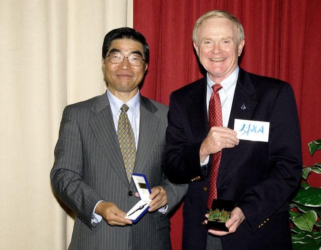 NASA image: KENNEDY SPACE CENTER, FLA. -  Executive Director of NASDA Koji Yamamoto (left) and Center Director Roy Bridges Jr. (right) exchange mementos during Mr. Yamamoto’s visit to KSC.  Mr. Bridges also holds the logo of the new Japan Aerospace Exploration Agency, a merger of three Japanese aeronautical and space agencies effective Oct.1, 2003.  Mr. Yamamoto is at KSC for a welcome ceremony involving the arrival of the newest Space Station module, the Japanese Experiment Module/pressurized module.  His visit includes a tour of the Columbia Debris Hangar.
