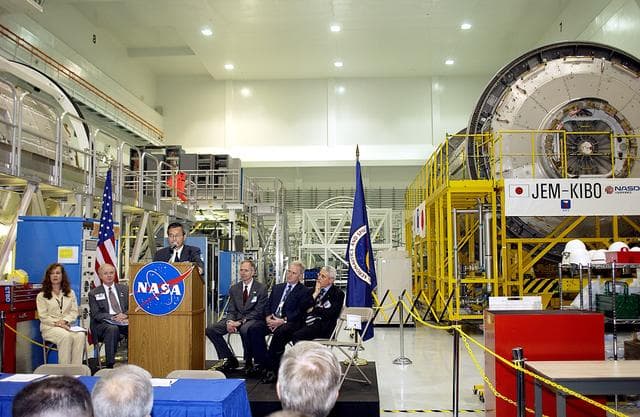 NASA image: KENNEDY SPACE CENTER, FLA. - Kuniaki Shiraki, JEM Project manager, National Aerospace and Development Agency of Japan,  speaks to guests and the media gathered in the Space Station Processing Facility at a ceremony highlighting the arrival of two major components of the International Space Station.  NASA's Node 2, built by the European Space Agency (ESA) in Italy, arrived at KSC on June 1. It will be the next pressurized module installed on the Station. The pressurized module (above right)  of the Japanese Experiment Module (JEM),  named "Kibo" (Hope), arrived at KSC on June 4. It is Japan's primary contribution to the Station. The ceremony held today included the official transfer of ownership signing of Node 2 between the ESA and NASA.. Emceed by Lisa Malone (far left), deputy director of External Relations and Business Development at KSC, the ceremony also included these speakers: Center Director Roy Bridges Jr. (second from left); NASA’s Michael C. Kostelnik, deputy associate administrator for International Space Station and Shuttle Programs and William Gerstenmaier, International Space Station Program manager ; Alan Thirkettle, International Space Station Program manager for Node 2, ESA; and Andrea Lorenzoni, International Space Station Program manager for Node 2, Italian Space Agency.