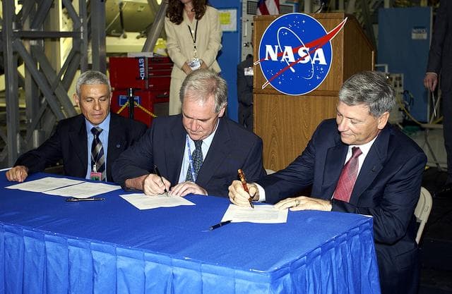 NASA image: KENNEDY SPACE CENTER, FLA. - Alan Thirkettle (center), International Space Station Program manager for Node 2, European Space Agency (ESA); and NASA’s Michael C. Kostelnik (right), deputy associate administrator for International Space Station and Shuttle Programs, sign documents officially transferring ownership of Node 2 between the ESA and NASA.  At left, also part of the signing, is Andrea Lorenzoni (left), International Space Station Program manager for Node 2, Italian Space Agency.  NASA's Node 2, built by ESA in Italy, arrived at KSC on June 1. It will be the next pressurized module installed on the Station. The pressurized module of the Japanese Experiment Module (JEM),  named "Kibo" (Hope), arrived at KSC on June 4. It is Japan's primary contribution to the Station. Emceed by Lisa Malone, deputy director of External Relations and Business Development at KSC, the ceremony also included these speakers: Center Director Roy Bridges Jr.; NASA’s William Gerstenmaier, International Space Station Program manager; and Kuniaki Shiraki, JEM Project manager, National Aerospace and Development Agency of Japan.