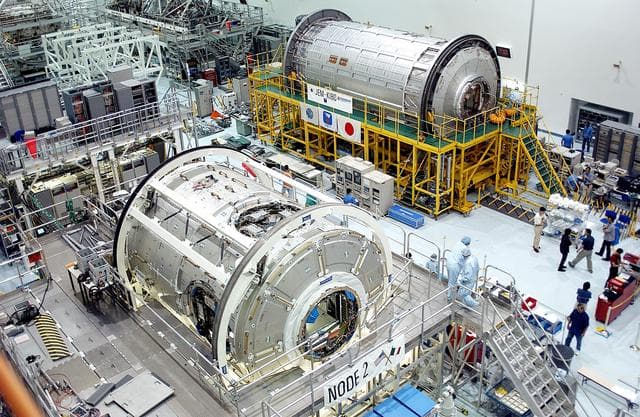 NASA image: KENNEDY SPACE CENTER, FLA. -  International Space Station elements being processed for launch on upcoming Space Shuttle flights, including the U.S. Node 2 and the Japanese Experiment Module (JEM) pressurized module, line the walls of the high bay in the Space Station Processing Facility. NASA's Node 2, built by the European Space Agency (ESA) in Italy, arrived at KSC on June 1. It will be the next pressurized module installed on the Station. The JEM pressurized module, named "Kibo" (Hope), arrived at KSC on June 4. It is Japan's primary contribution to the Station.