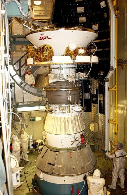 NASA image: KENNEDY SPACE CENTER, FLA. - At Launch Complex 17-B, Cape Canaveral Air Force Station, workers prepare to install the spacecraft fairing around the Mars Exploration Rover-1 (MER-B). The second of twin rovers being sent to Mars, it is equipped with a robotic arm, a drilling tool, three spectrometers, and four pairs of cameras that allow it to have a human-like, 3D view of the terrain. Each rover could travel as far as 100 meters in one day to act as Mars scientists' eyes and hands, exploring an environment where humans are not yet able to go. MER-B is scheduled to launch no earlier than June 28 at one of two available times, 11:56:16 p.m. EDT or 12:37:59 a.m. EDT.