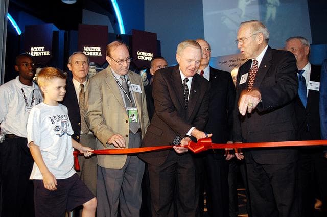 NASA image: KENNEDY SPACE CENTER, FLA. -  Center Director and former astronaut Roy D. Bridges, Jr., (holding scissors) cuts the ribbon at a ceremony officially opening the U.S. Astronaut Hall of Fame as part of the Kennedy Space Center Visitor Complex.  Invited guests and dignitaries look on, such as former astronauts Edgar D. Mitchell on Bridges' left and James Lovell on his right.  The ceremony was held in conjunction with the induction of four Space Shuttle astronauts into the Hall of Fame including Daniel Brandenstein, Robert "Hoot" Gibson, Story Musgrave, and Sally Ride.  Conceived by six of the Mercury Program astronauts, the U.S. Astronaut Hall of Fame opened in 1990 to provide a place where space travelers could be remembered for their participation and accomplishments in the U.S. space program.  The four new inductees join 48 previously honored astronauts from the ranks of the Gemini, Apollo, Skylab, Apollo-Soyuz, and Space Shuttle programs.