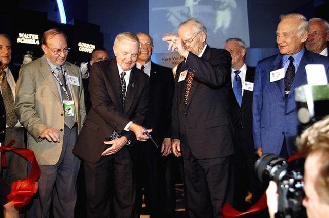 NASA image: KENNEDY SPACE CENTER, FLA. -  Center Director and former astronaut Roy D. Bridges, Jr., (holding scissors) cuts the ribbon at a ceremony officially opening the U.S. Astronaut Hall of Fame as part of the Kennedy Space Center Visitor Complex.  Invited guests and dignitaries look on, such as former astronauts Edgar D. Mitchell on Bridges' left and James Lovell (hand up) and Buzz Aldrin on his right.  The ceremony was held in conjunction with the induction of four Space Shuttle astronauts into the Hall of Fame including Daniel Brandenstein, Robert "Hoot" Gibson, Story Musgrave, and Sally Ride.  Conceived by six of the Mercury Program astronauts, the U.S. Astronaut Hall of Fame opened in 1990 to provide a place where space travelers could be remembered for their participation and accomplishments in the U.S. space program.  The four new inductees join 48 previously honored astronauts from the ranks of the Gemini, Apollo, Skylab, Apollo-Soyuz, and Space Shuttle programs.