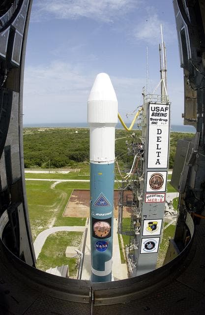 NASA image: KENNEDY SPACE CENTER, FLA. -  The Mobile Service Tower is rolled back at Space Launch Complex 17B, Cape Canaveral Air Force Station, to reveal the Delta II Heavy launch vehicle ready for launch of the Mars Exploration Rover-B (MER-B) mission, with the rover "Opportunity" aboard. The second of twin rovers being sent to Mars, it is equipped with a robotic arm, a drilling tool, three spectrometers, and four pairs of cameras that allow it to have a human-like, 3D view of the terrain. Each rover could travel as far as 100 meters in one day to act as Mars scientists' eyes and hands, exploring an environment where humans are not yet able to go. MER-B is scheduled to launch on June 28 at one of two available times, 11:56:16 p.m. EDT or 12:37:59 a.m. EDT on June 29.