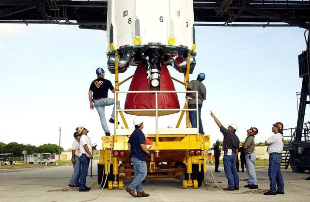 NASA image: KENNEDY SPACE CENTER, FLA. -  Workers on Launch Complex 17-B, Cape Canaveral Air Force Station, prepare the first stage of a Delta II rocket for its lift up the mobile service tower.  The rocket is being erected to launch the Space InfraRed Telescope Facility (SIRTF).  Consisting of an 0.85-meter telescope and three cryogenically cooled science instruments, SIRTF is one of NASA's largest infrared telescopes to be launched.  SIRTF will obtain images and spectra by detecting the infrared energy, or heat, radiated by objects in space. Most of this infrared radiation is blocked by the Earth's atmosphere and cannot be observed from the ground.
