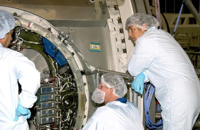NASA image: KENNEDY SPACE CENTER, FLA. -  In the Space Station Processing Facility, STS-115 Mission Specialists Joseph Tanner (center) and Heidemarie Stefanyshyn-Piper (right)  look at the inside of the Japanese Experiment Module (JEM) Pressurized Module. Known as Kibo, the JEM consists of six components: two research facilities -- the Pressurized Module and Exposed Facility; a Logistics Module attached to each of them; a Remote Manipulator System; and an Inter-Orbit Communication System unit. Kibo also has a scientific airlock through which experiments are transferred and exposed to the external environment of space. The various components of JEM will be assembled in space over the course of three Space Shuttle missions.    The STS-115  mission will deliver the second port truss segment, the P3/P4 Truss, to attach to the first port truss segment, the P1 Truss, as well as deploy solar array sets 2A and 4A..  The crew is scheduled to activate and check out the Solar Alpha Rotary Joint (SARJ) and deploy the P4 Truss radiator.