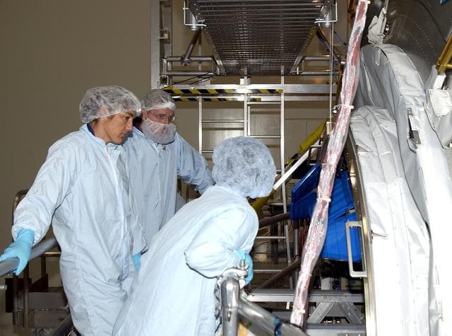NASA image: KENNEDY SPACE CENTER, FLA. - In the Space Station Processing Facility, STS-115 Mission Specialists Heidemarie Stefanyshyn-Piper (left) and Joseph Tanner (center) get ready to check out the Japanese Experiment Module (JEM) Pressurized Module. Known as Kibo, the JEM consists of six components: two research facilities -- the Pressurized Module and Exposed Facility; a Logistics Module attached to each of them; a Remote Manipulator System; and an Inter-Orbit Communication System unit. Kibo also has a scientific airlock through which experiments are transferred and exposed to the external environment of space. The various components of JEM will be assembled in space over the course of three Space Shuttle missions.   The STS-115  mission will deliver the second port truss segment, the P3/P4 Truss, to attach to the first port truss segment, the P1 Truss, as well as deploy solar array sets 2A and 4A..  The crew is scheduled to activate and check out the Solar Alpha Rotary Joint (SARJ) and deploy the P4 Truss radiator.