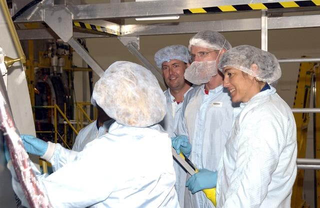 KENNEDY SPACE CENTER, FLA. - In the Space Station Processing Facility, STS-120 Mission Specialists Michael Foreman (third from right) and STS-115 Mission Specialists Joseph Tanner (second from right) and Heidemarie Stefanyshyn-Piper (right) look over the Japanese Experiment Module (JEM) Pressurized Module. Known as Kibo, the JEM consists of six components: two research facilities -- the Pressurized Module and Exposed Facility; a Logistics Module attached to each of them; a Remote Manipulator System; and an Inter-Orbit Communication System unit. Kibo also has a scientific airlock through which experiments are transferred and exposed to the external environment of space. The various components of JEM will be assembled in space over the course of three Space Shuttle missions.  STS-115 will deliver the second port truss segment, the P3/P4 Truss, to attach to the first port truss segment, the P1 Truss, as well as deploy solar array sets 2A and 4A.. STS-120 will deliver the second of three Station connecting modules, Node 2, which attaches to the end of U.S. Lab.  It will provide attach locations for the Japanese laboratory, European laboratory, the Centrifuge  Accommodation Module and later Multi-Purpose Logistics Modules.  The addition of Node 2 will complete the U.S. core of the International Space Station.
