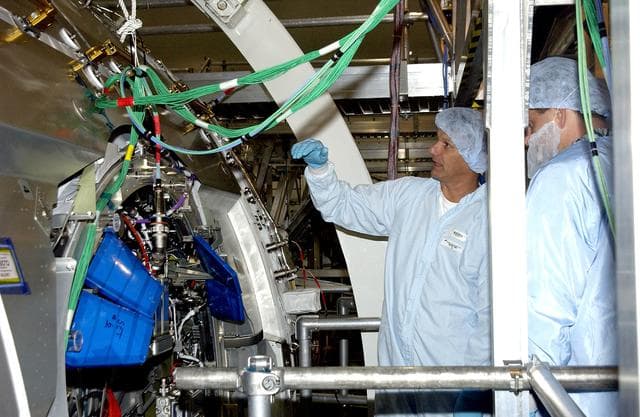 NASA image: KENNEDY SPACE CENTER, FLA. - STS-120 Mission Specialists Piers Sellers and Michael Foreman look at the Japanese Experiment Module (JEM) Pressurized Module located in the Space Station Processing Facility. Known as Kibo, the JEM consists of six components: two research facilities -- the Pressurized Module and Exposed Facility; a Logistics Module attached to each of them; a Remote Manipulator System; and an Inter-Orbit Communication System unit. Kibo also has a scientific airlock through which experiments are transferred and exposed to the external environment of space. The various components of JEM will be assembled in space over the course of three Space Shuttle missions.  The STS-120 mission will deliver the second of three Station connecting modules, Node 2, which attaches to the end of U.S. Lab.  It will provide attach locations for the JEM, European laboratory, the Centrifuge Accommodation Module and later Multi-Purpose Logistics Modules.  The addition of Node 2 will complete the U.S. core of the International Space Station.