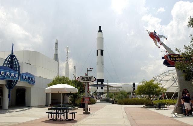 NASA image: KENNEDY SPACE CENTER, FLA.  -  Several exhibit entrances within the KSC Visitor Complex are seen: The Universe Theatre, which shows the film “Quest for Life”;  Mad Mission to Mars 2025, a live-action stage show; and, in the background, the Rocket Garden, featuring eight authentic rockets from the past.