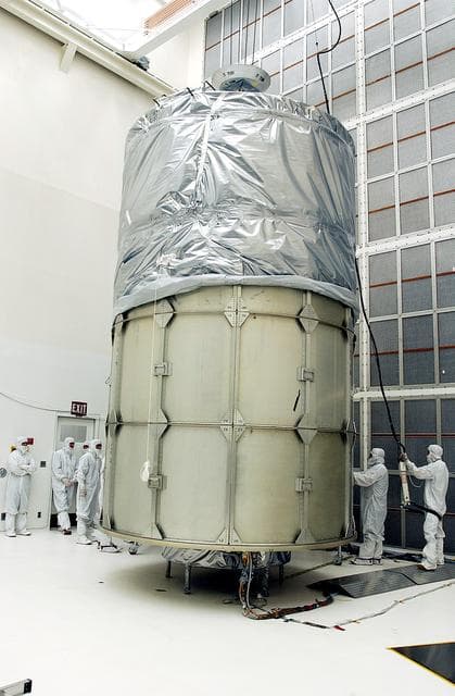 NASA image: KENNEDY SPACE CENTER, FLA.  -  In Hangar A&E, Cape Canaveral Air Force Station, encapsulation of the Space Infrared Telescope Facility (SIRTF) is complete.  The spacecraft will be transported to Launch Complex 17-B for mating with its launch vehicle, the Delta II rocket.   SIRTF consists of three cryogenically cooled science instruments and an 0.85-meter telescope, and is one of NASA's largest infrared telescopes to be launched.  SIRTF will obtain images and spectra by detecting the infrared energy, or heat, radiated by objects in space. Most of this infrared radiation is blocked by the Earth's atmosphere and cannot be observed from the ground.